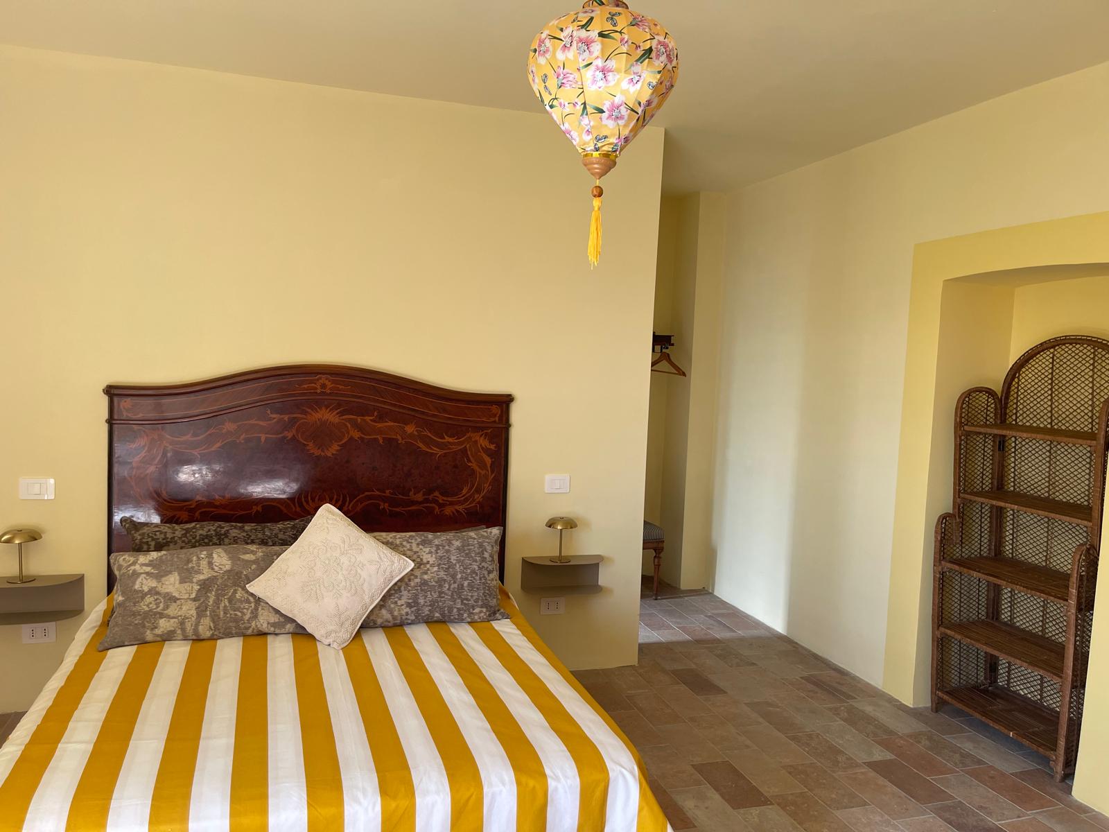 Camera Mimosa al B&B Casale Le Casole a Otricoli: atmosfera luminosa, dettagli floreali e campagna umbra